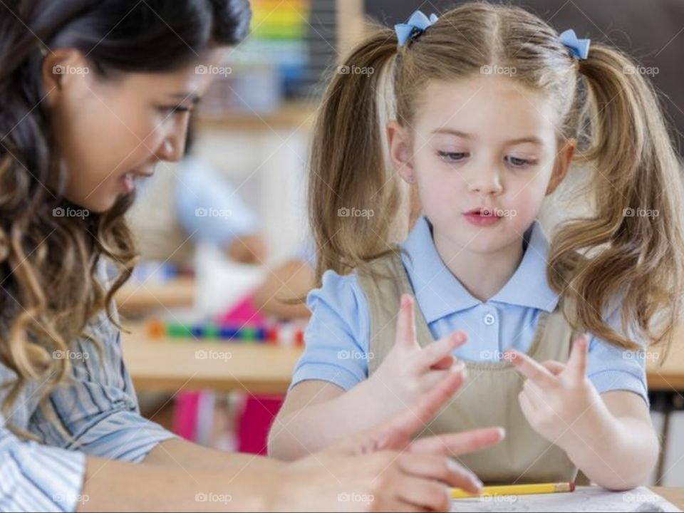 Mam giving the knowledge of minus plus to the children.