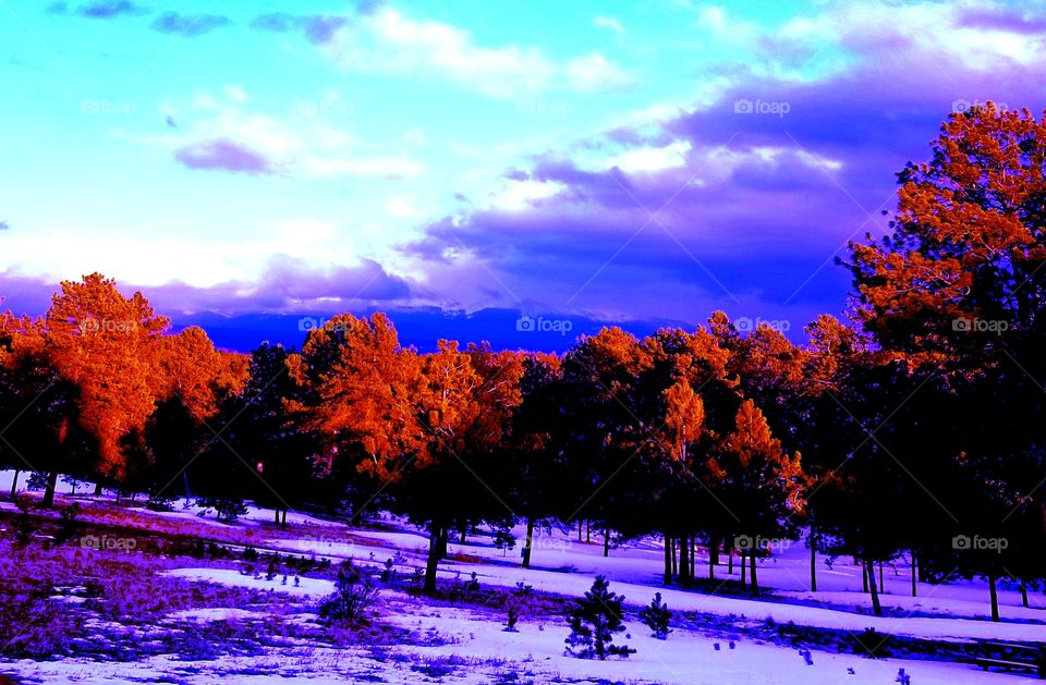 Most colorful scenic landscape of Colorado mountains, blue sky filled with white clouds and snow covered ground.