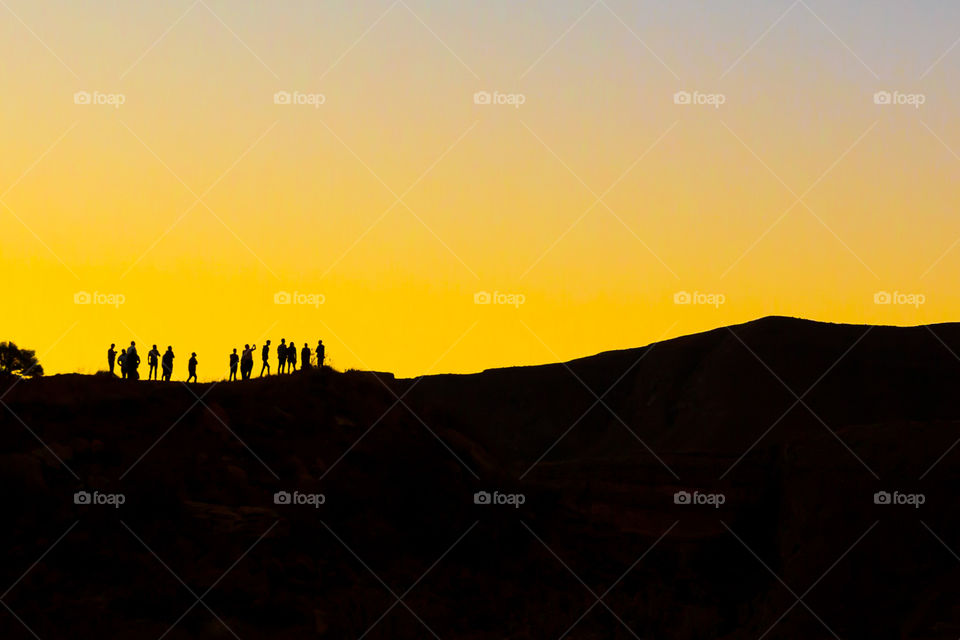 Orange! Group of friends silhouetted against and orange sunset