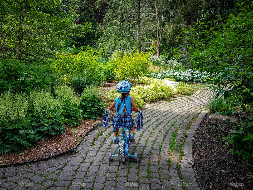 Little girl is riding bicycle in the park