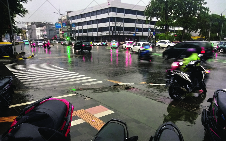 Rain in the afternoon at the intersection near the traffic light and zebra cross