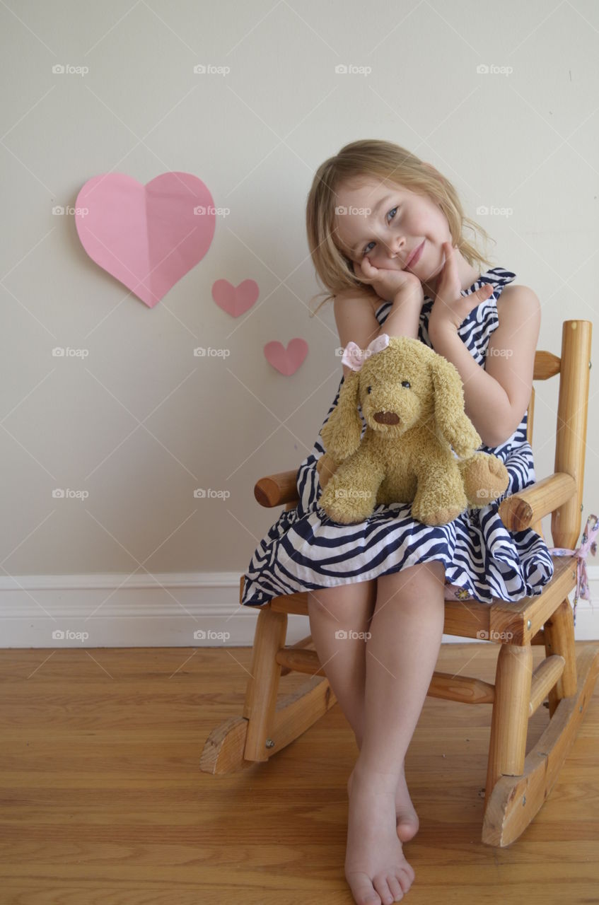 Smiling girl sitting on wooden chair in home