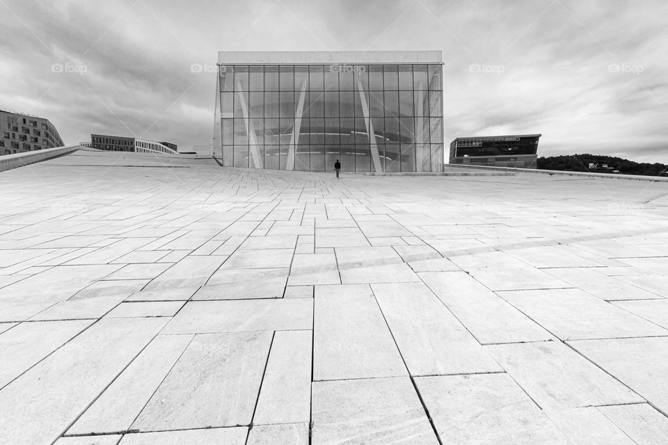 One man walking towards the opera house in Oslo Norway