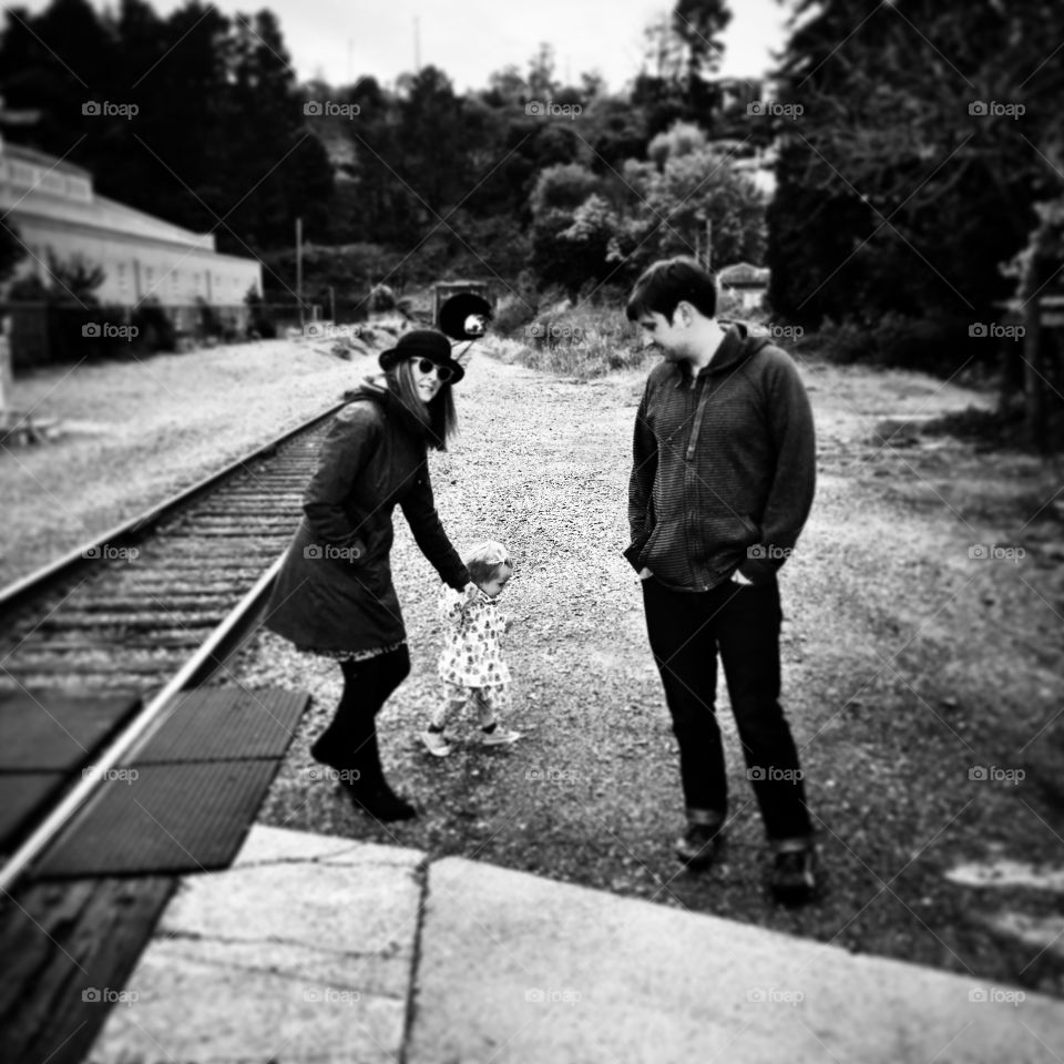 Father and mother with their daughter near railtrack