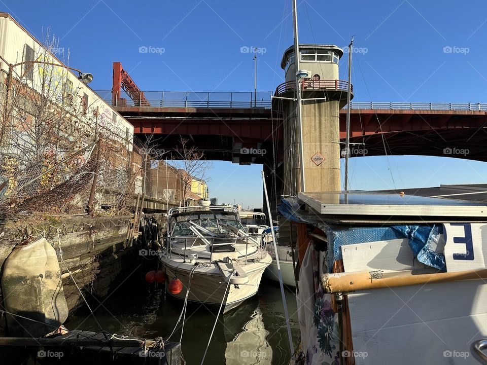 This is the “Pulaski Bridge” at “Newtown Creek”, an ocean inlet of the “East River” in LIC, Queens seen from the “28 foot 1969 Luhrs” cabin cruiser that is home to myself and my longtime partner “Timothy Trespas”. 2023. Hypnotic Productions