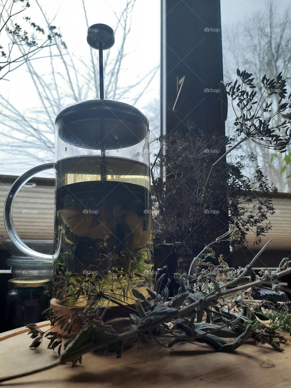 winter season breverages: herbs and apple infusion against winter view behind window