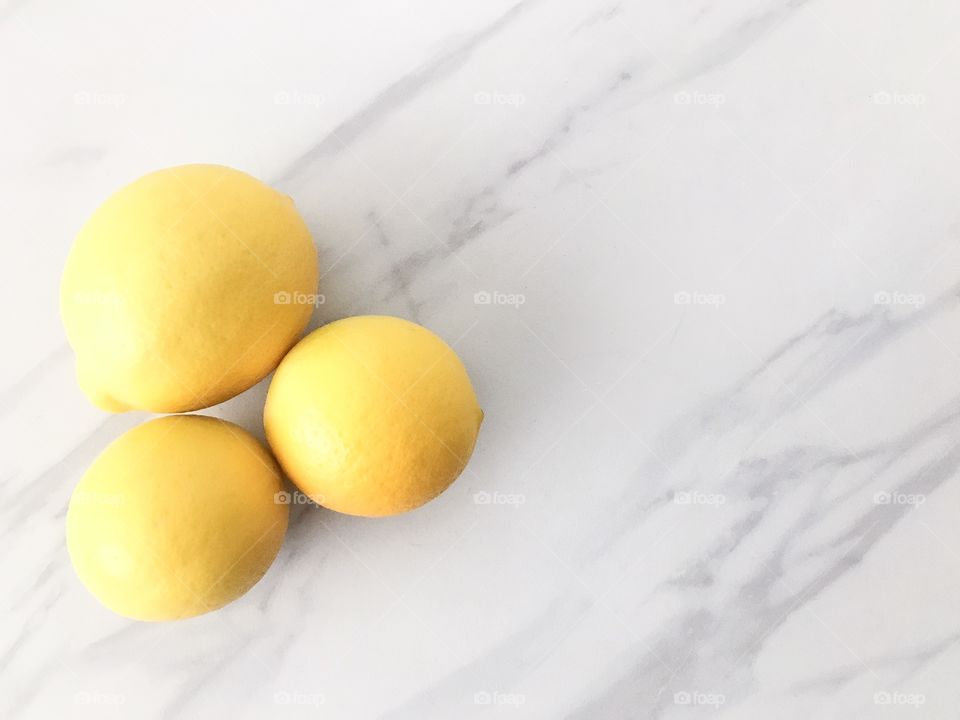 Bright yellow lemons on a marble counter