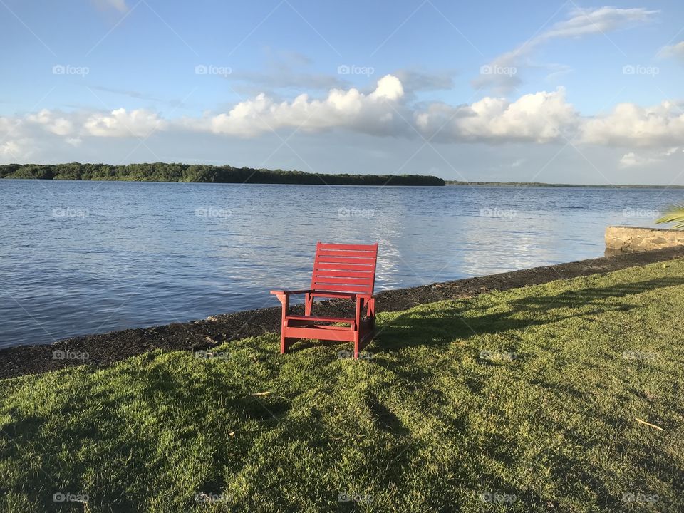 a red chair beside the Jaguaripe riverbank on a farm