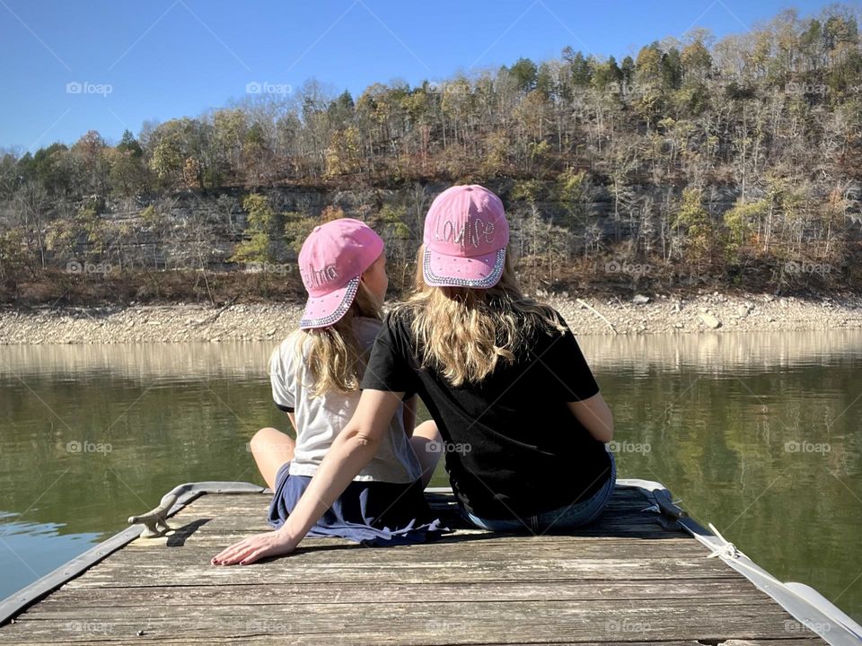 Mother and daughter sitting on the dock