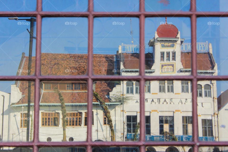 Portrait of a typical Dutch colonial heritage from the reflection of a window glass of a shop in the old city of Jakarta.