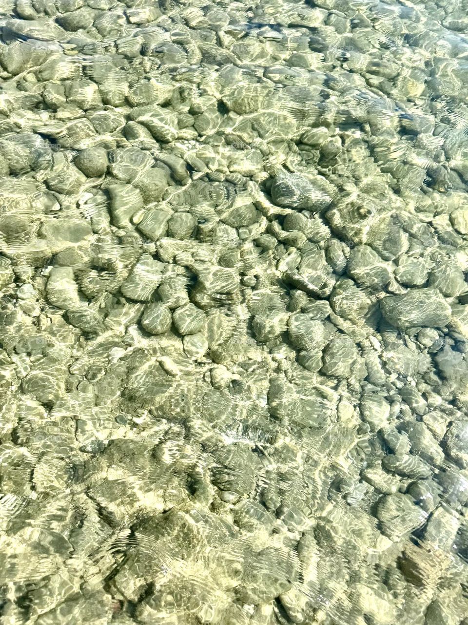 Transparent sea water. Pebbles. Bottom. Background