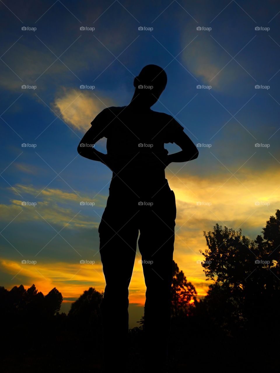 its golden hour time, sunset, spectrum of sunset rays, standing and feeling the warm and beauty of nature, blue and cloudy sky,