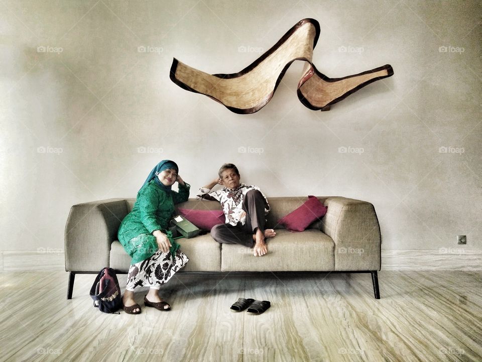 indonesian husband and wife comfortly waiting on a couch.