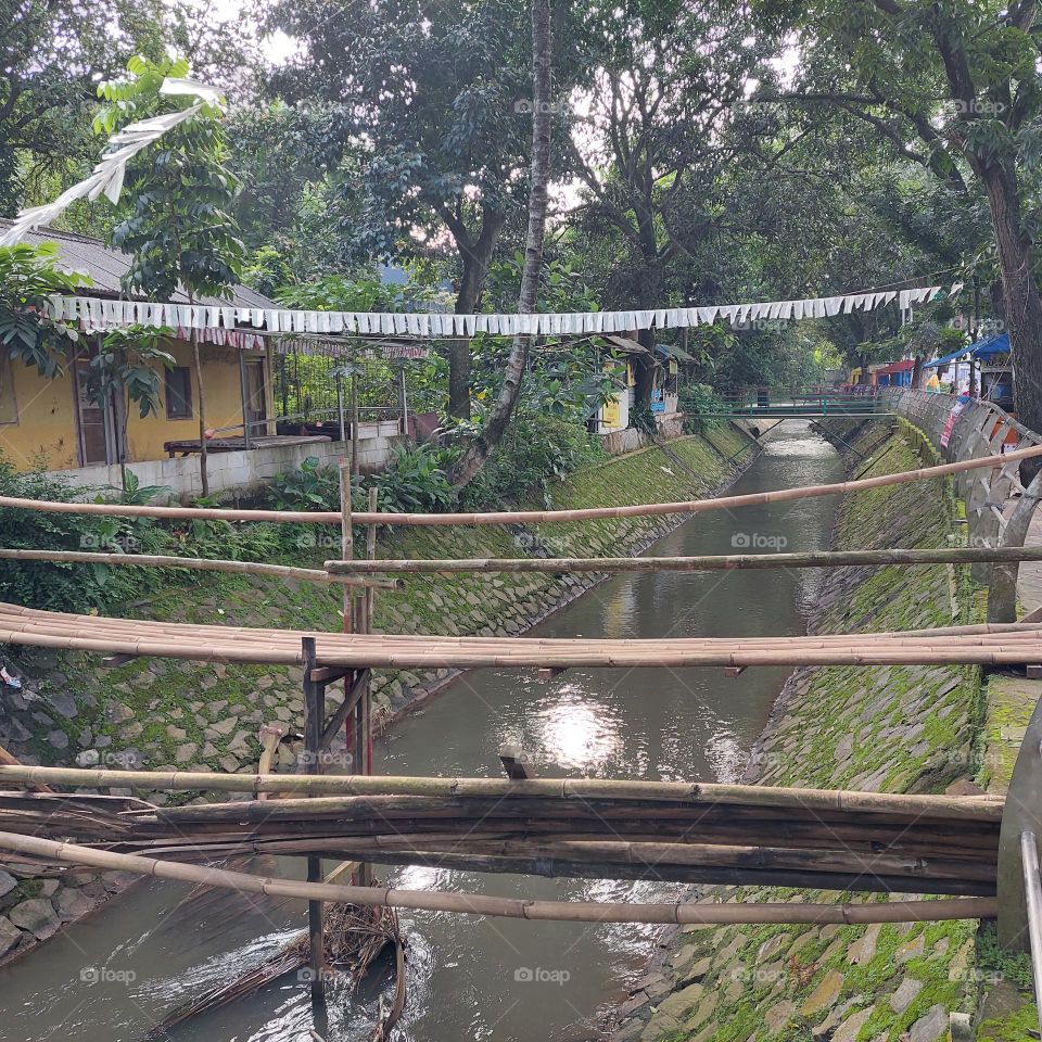 bamboo bridge over the river with clear water