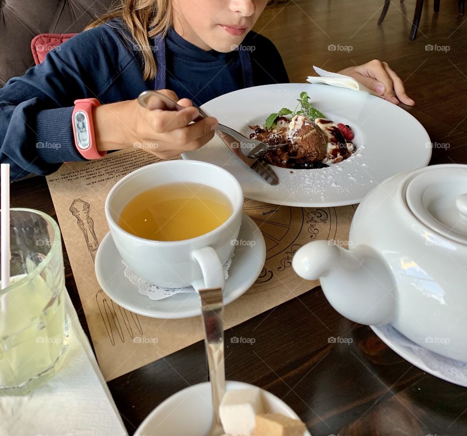 Appetizing Dessert - Chocolate Fondant. The Girl eating a cake in a cafe
