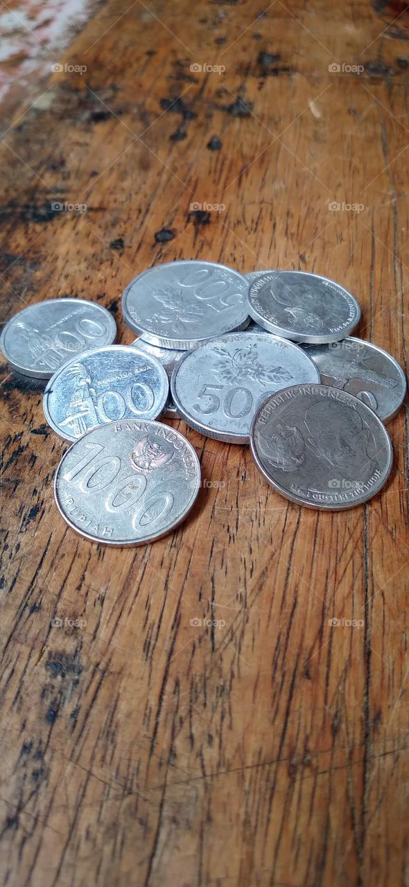 Rupiah coins on an ancient wooden table