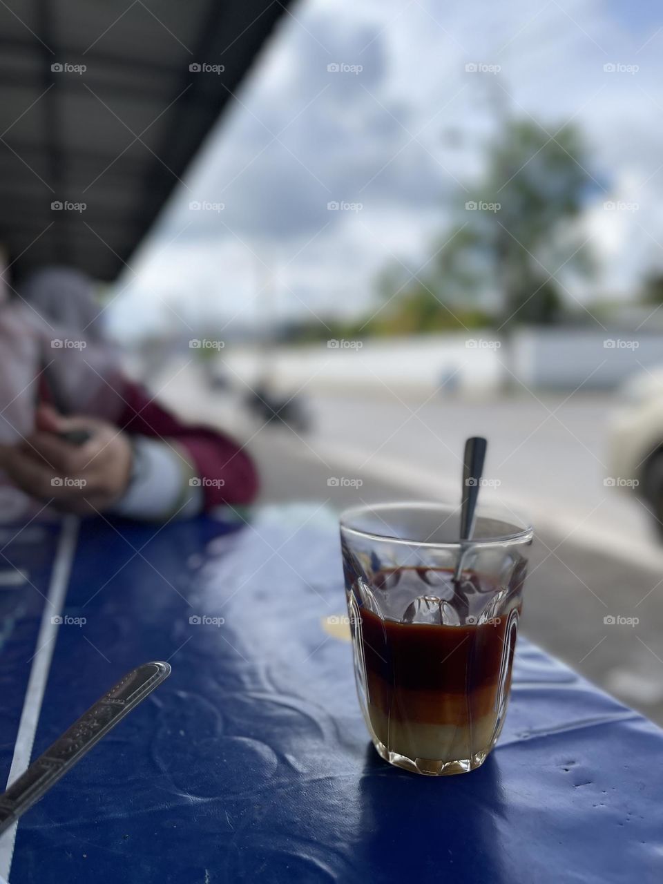 Three layered Thai tea on a table beside the road