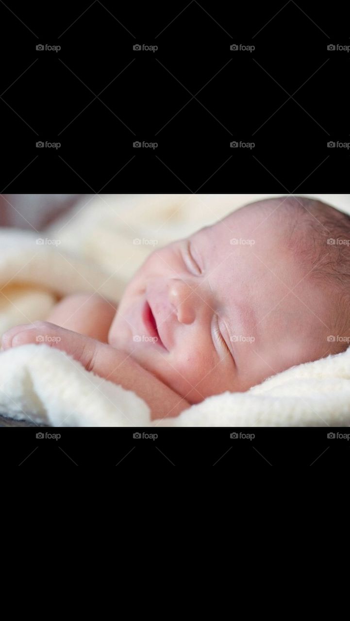 Baby boy smiling in his sleep