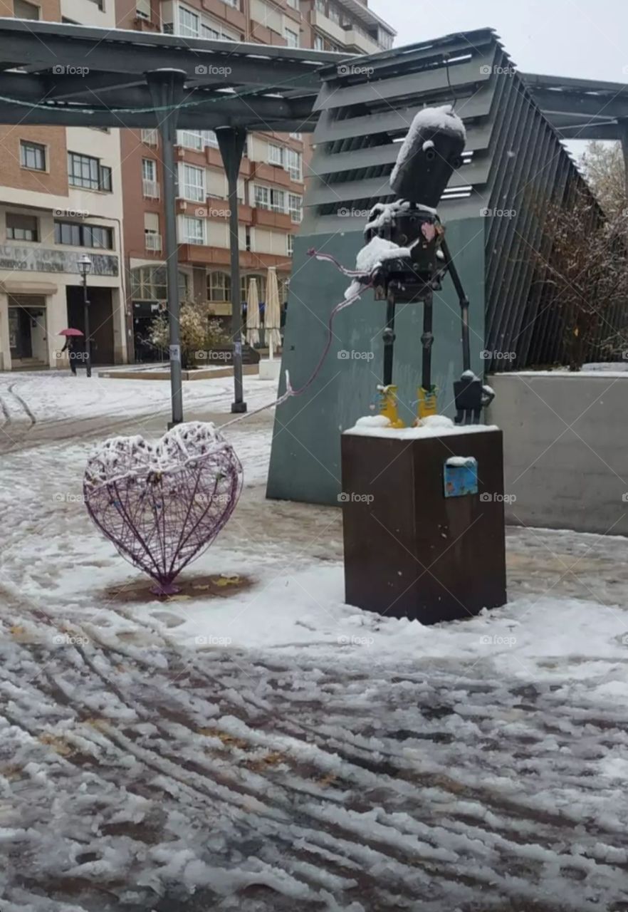 Robot with heart on a snowy background