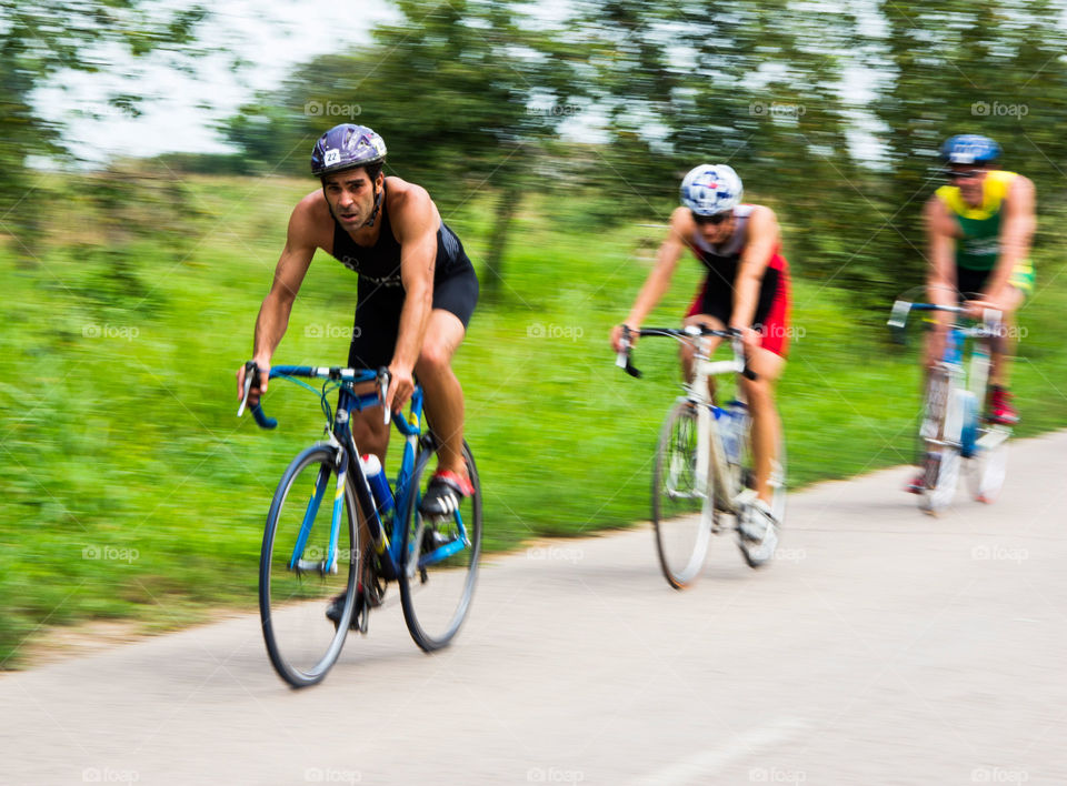 man racing on bikes. three male contestant in a triathlon race in Mali Stapar,Serbia,summer 2014