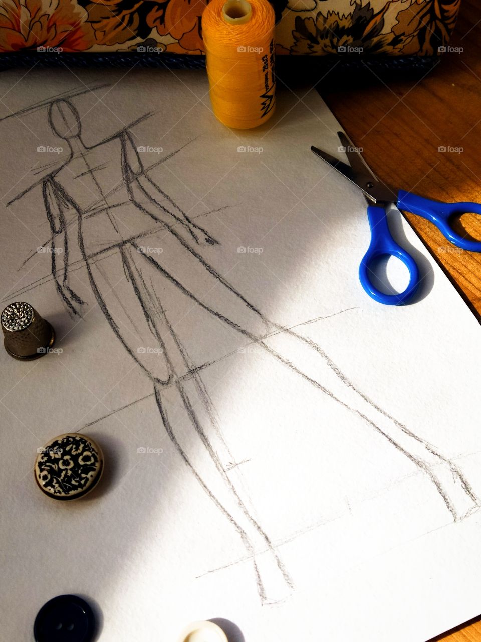 Sketch of a human body on a sheet of paper, buttons, scissors