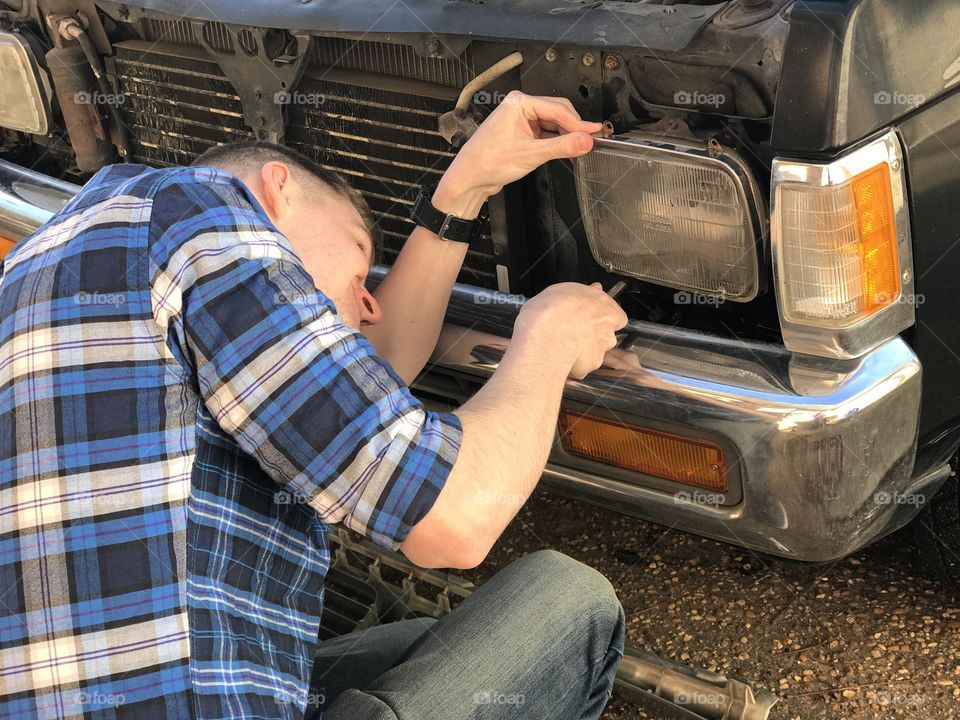 Young man working on aa older model truck.