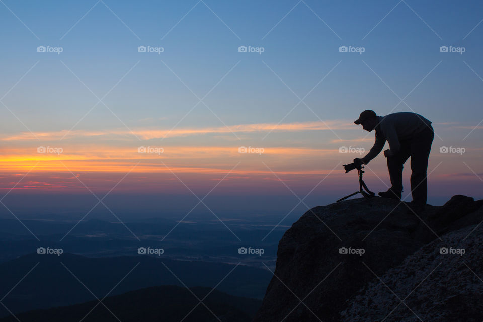 A photographer overlooking the Virginia Piedmont from Old Rag at dawn. 
