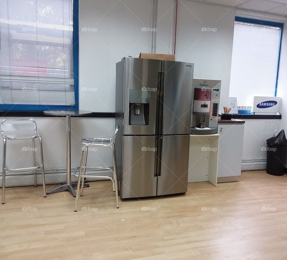 Samsung American style fridge in room with chrome chairs and table and coffee machine