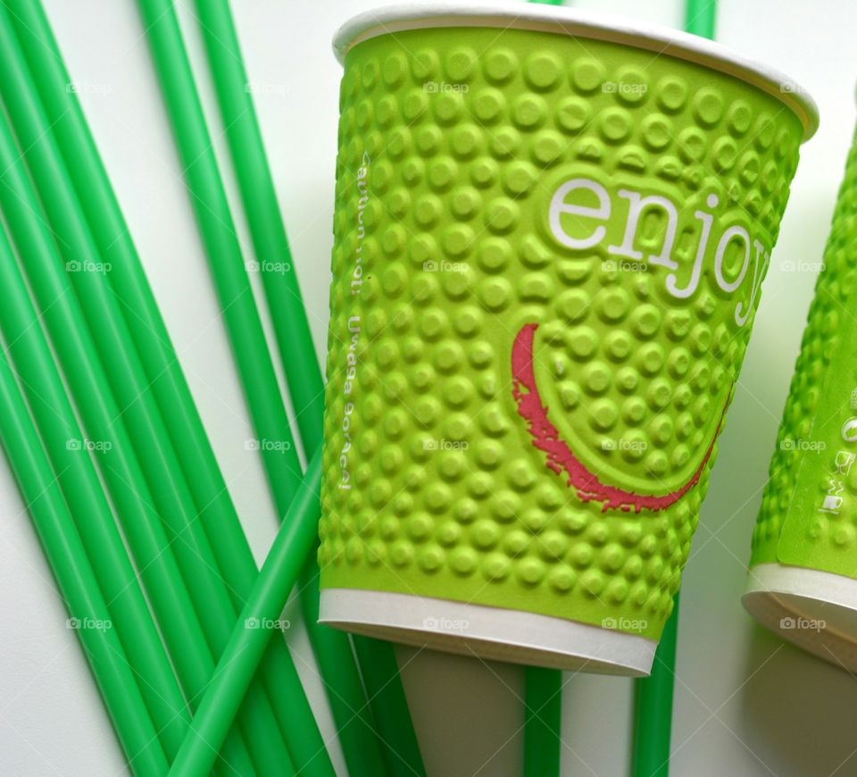 Green disposable cup with drinking straws