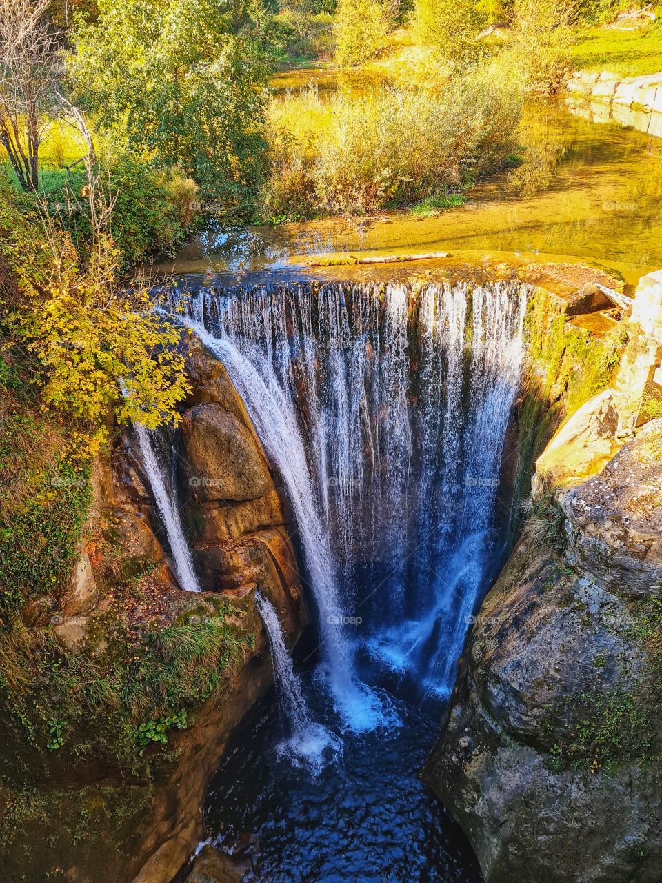 waterfall surrounded by nature and autumn colors