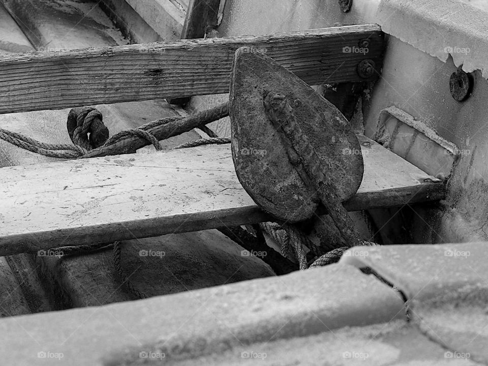 Rusty anchor sits inside a boat.