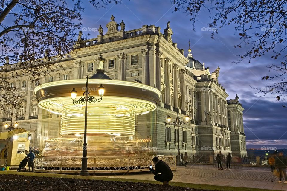 Spinning carousel in front of the Royal Palace at night 