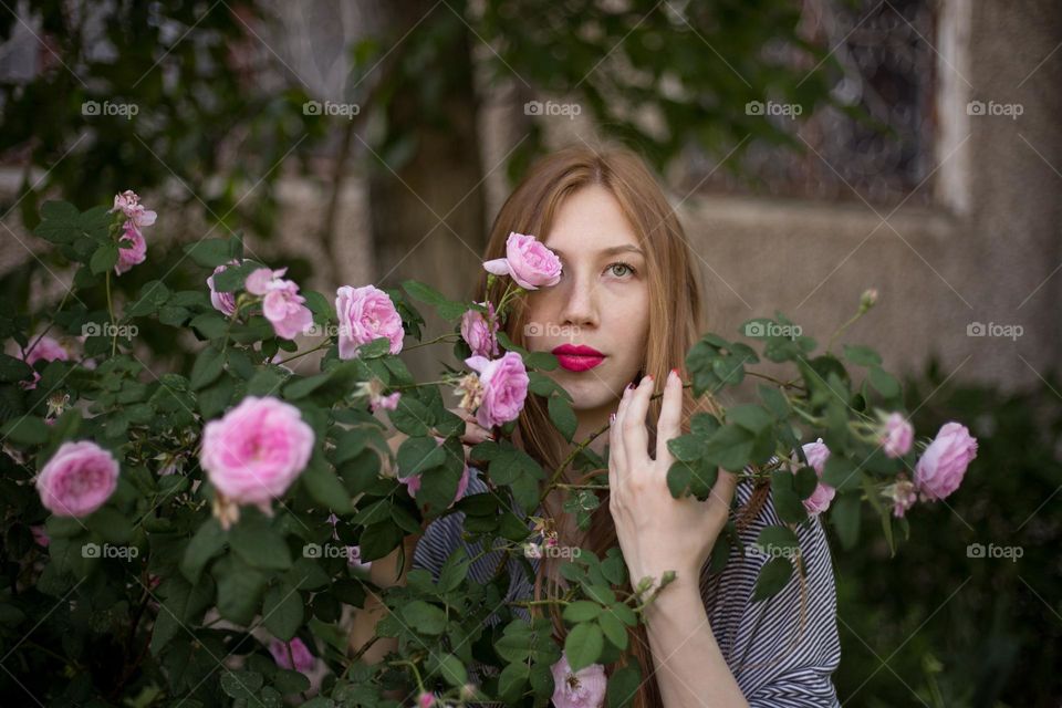 Portrait of beautiful woman with pink roses 