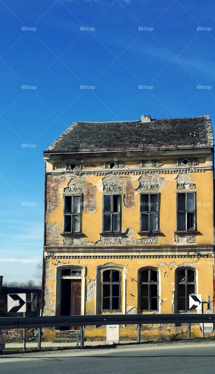 a very old yellow house and blue sky