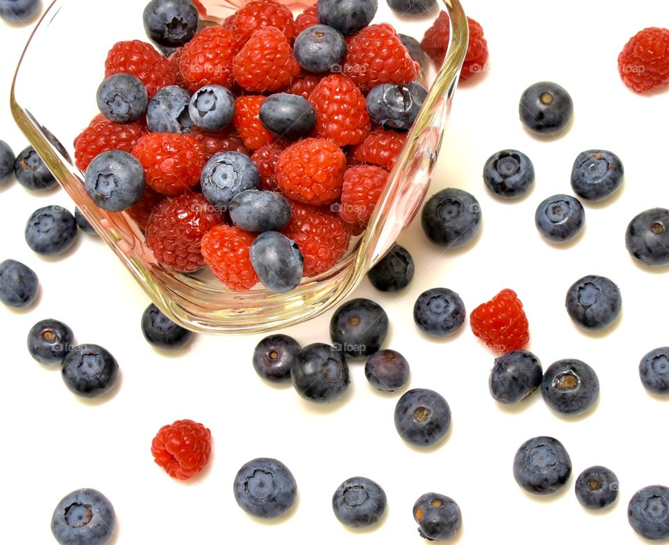 Red raspberries and blueberries flat lay design