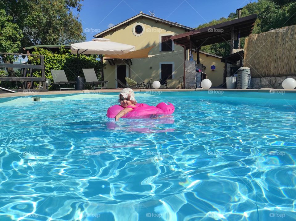 baby girl in the pool with lifebuoy