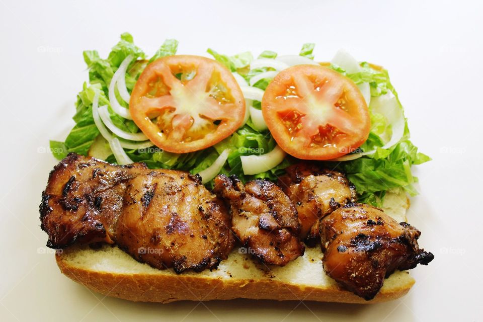 grilled chicken sandwich with lettuce, tomatoes and onions